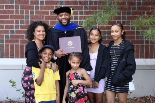 Michael with his wife and kids after the ceremony where he received his Ph.D.